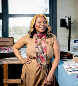 Nisha Blackwell smilingly confidently in her workshop