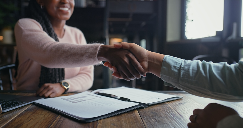 People shaking hands after signing documents
