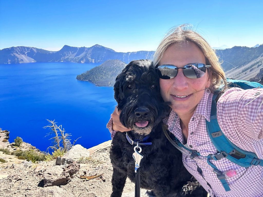 Lisa Tannenbaum in front of a scenic background with her dog