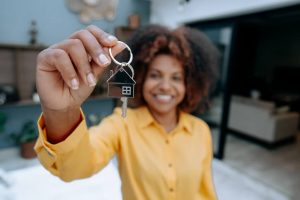 Woman holding up house keys and smiling