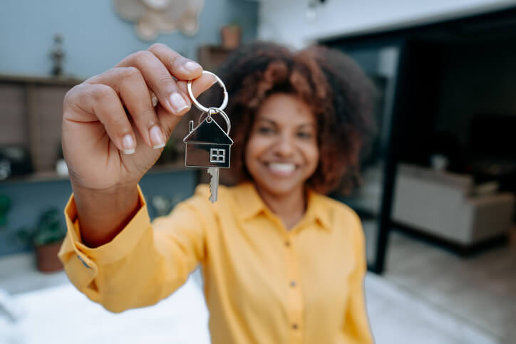 Woman holding up house keys and smiling