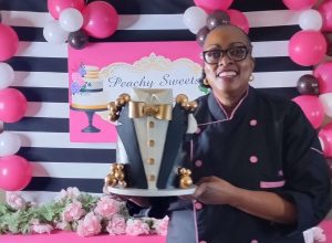 Aisha Price holding a cake to commemorate her Biddy Mason Award