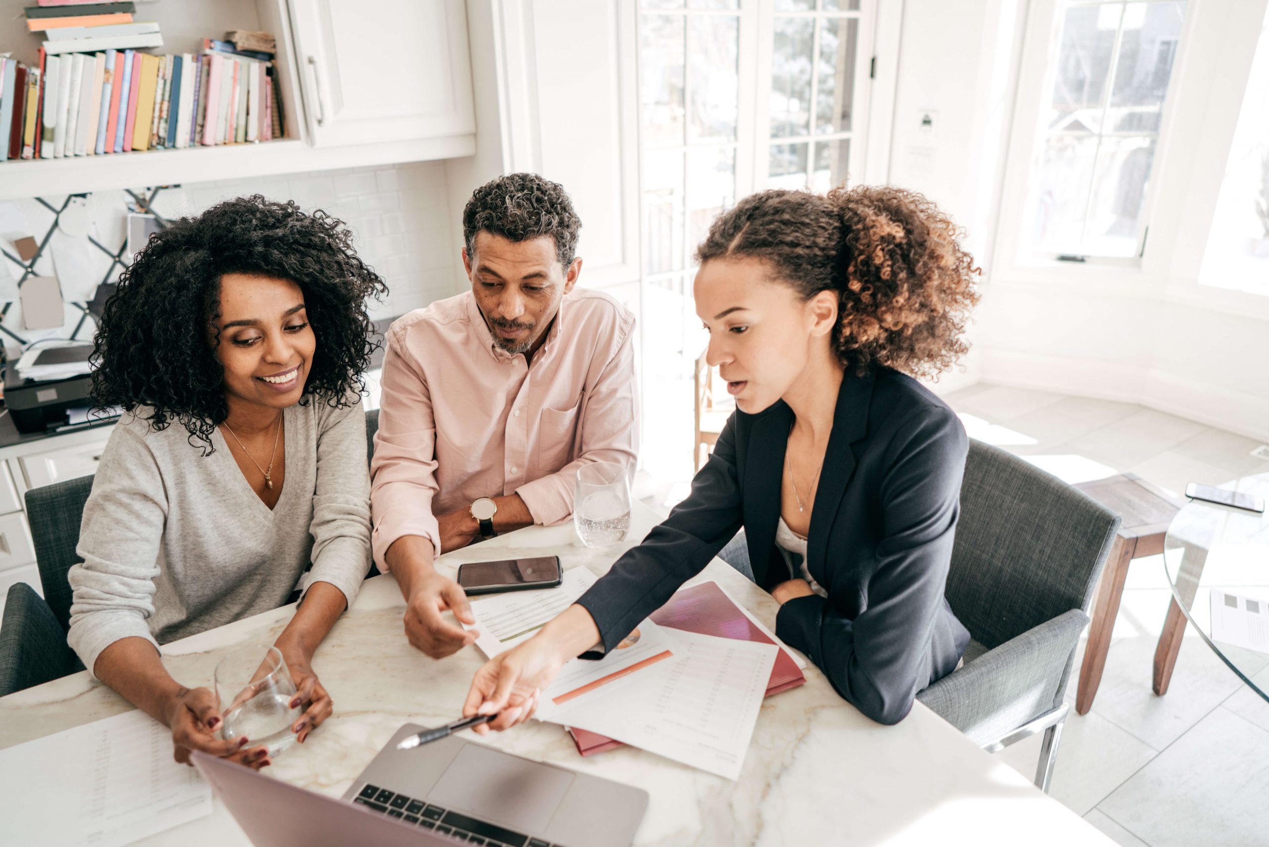 People discussing finances, pointing at laptop screen