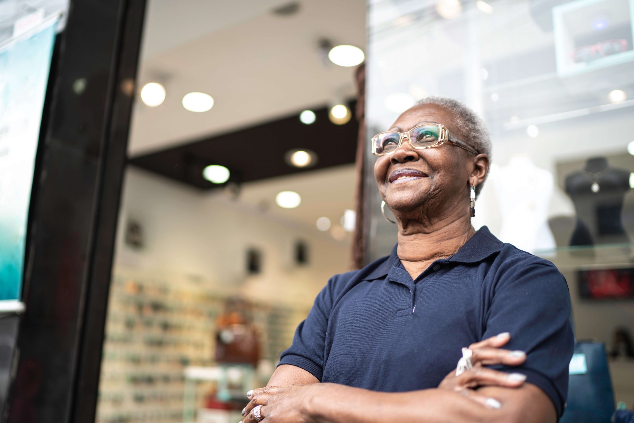 Woman standing in front of shop window, smiling