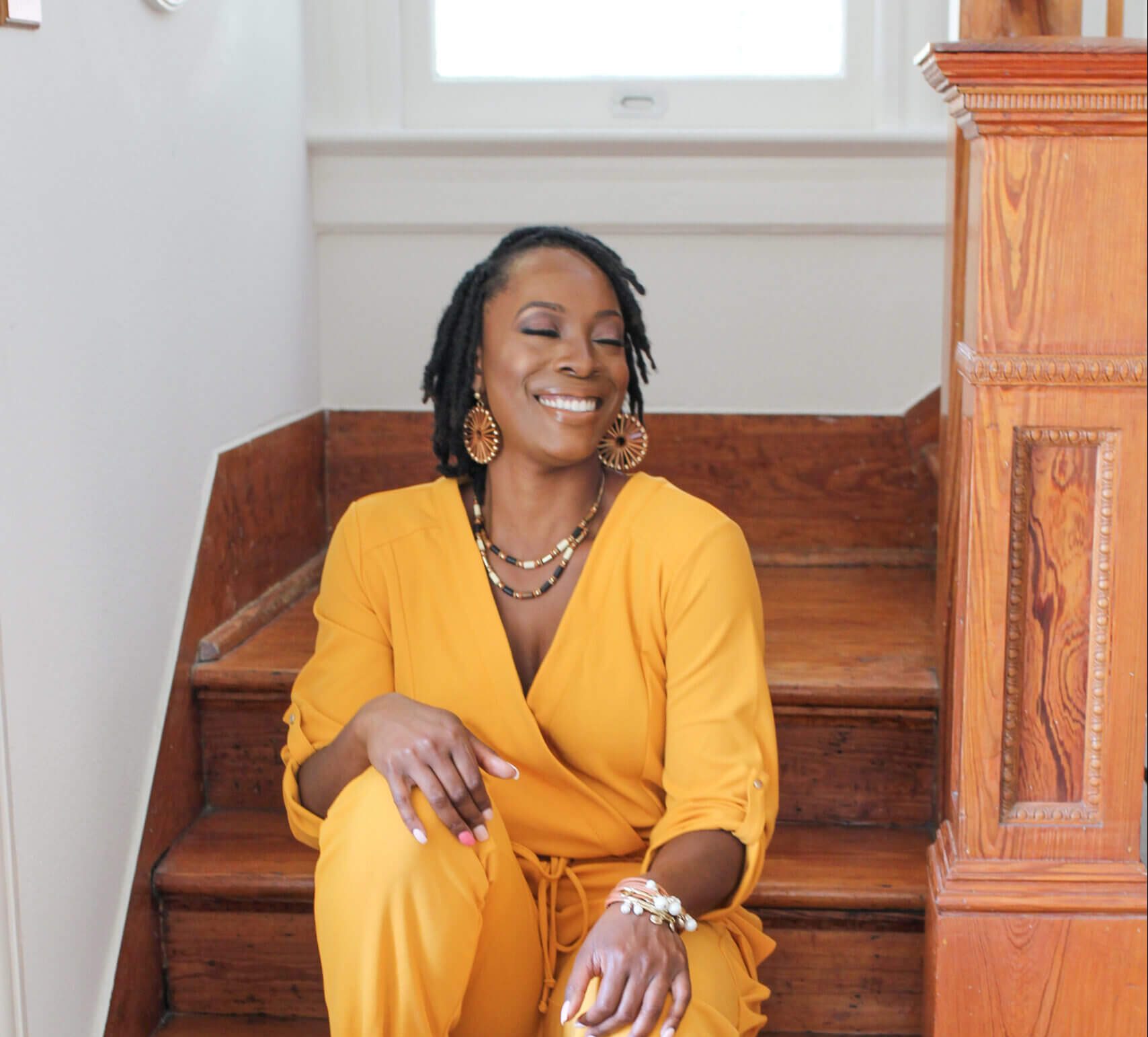 Woman smiling, sitting on a staircase